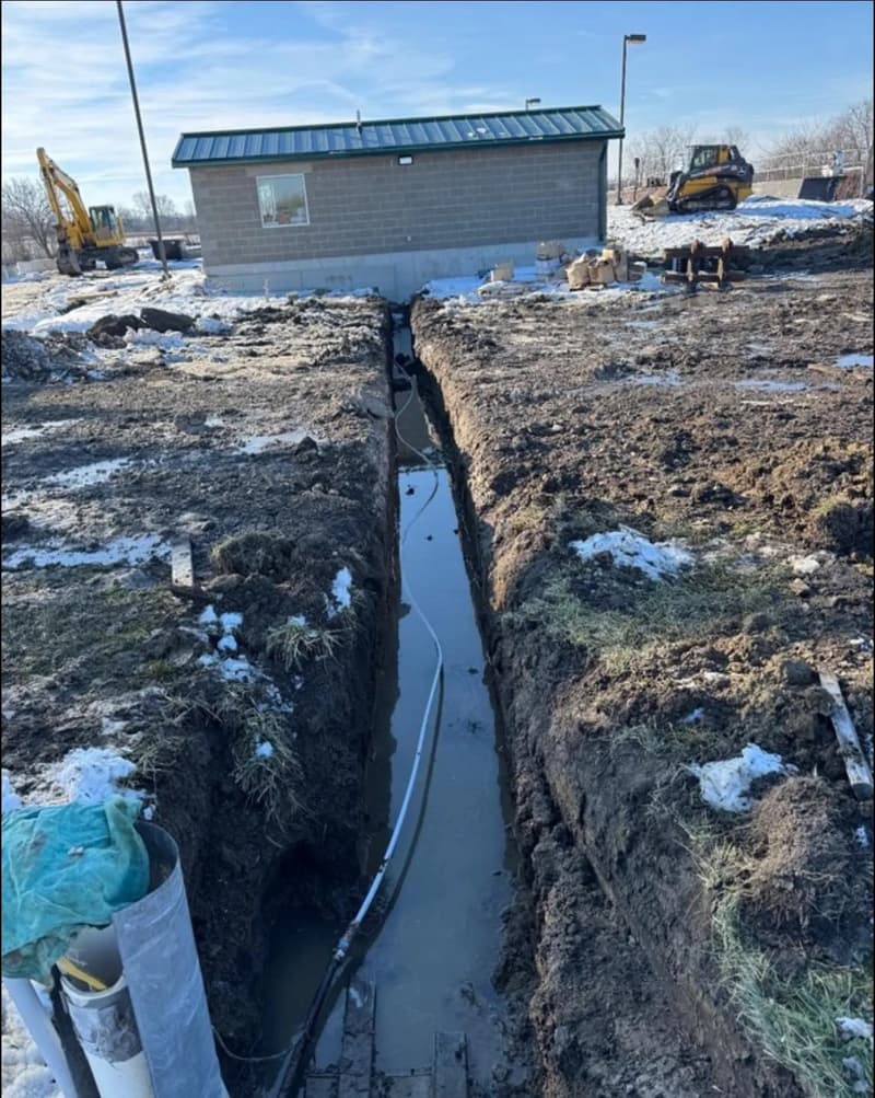 Water-filled trench dug beside a small building